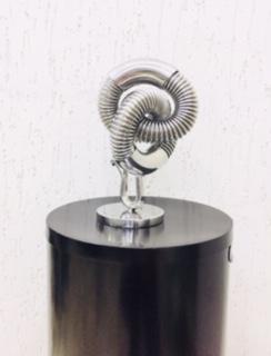 Beautiful design defines contemporary style and elegance and Brazilian Artist Luiz Campoy delivers whimsical and elegant sculptures every time. This is NO, a stainless steel hook welded in standardized bent steel, mixing accordion tubes set in the bends. On a solid round base, all polished to an incredible gleam. Perfect as a showpiece. Artist: Luiz Campoy Medium: Stainless steel Genre: Abstract Sculpture Shipped directly from artist's studio Signed by artist