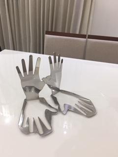 An abstract expression, this modern set of stainless steel hands are upright yet, also mirrored in their base. Signed by the artist, this piece is laser cut, with a thickness of 5mm solid, and the contour of the piece provides the solid base of the sculp